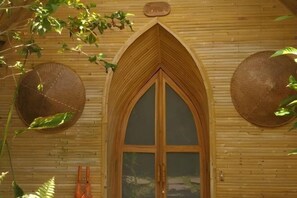 Une pièce en bois avec une grande fenêtre en arc de cercle et deux décorations murales rondes.