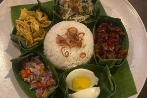Une assiette remplie de riz, d’œufs et de différents plats.