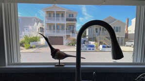 A kitchen with a modern faucet and a window overlooking a residential street. - 3-bdrm in Ship Bottom. 2 blocks from beach and bars. Surfboards included! (Ship Bottom)