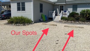 A two-story house with a small attached garage, a front porch with a white railing, and a driveway with a gravel area. - 3-bdrm in Ship Bottom. 2 blocks from beach and bars. Surfboards included! (Ship Bottom)