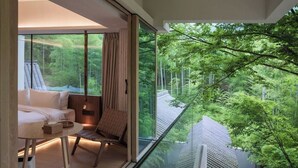 Une chambre moderne avec une grande fenêtre, un lit, une chaise et une table.