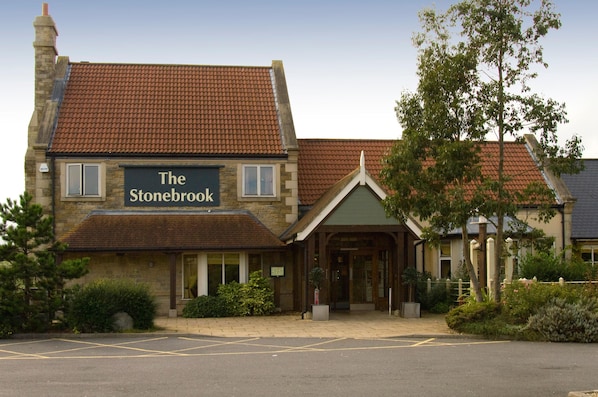 Un edificio de piedra con un letrero que dice 'The Stonebrook'.