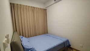 A small, single-bed room with a beige curtain, a blue bedspread, and an air conditioning unit mounted on the wall. - Corner unit 3R3B2cp condo, 550 sf terrace/balcony and AC in Kuala Lumpur (Kuala Lumpur)