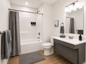 Ein modernes Badezimmer mit Badewanne, Toilette und Waschtisch.