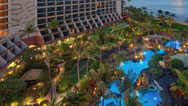 A resort with multiple swimming pools surrounded by palm trees and a beach.