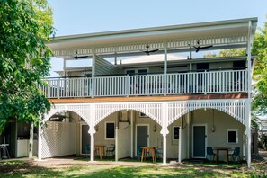 A two-story building with a balcony, covered patio, and arched entryways.