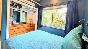 A bedroom with a bed, dresser, mirror, and window with curtains. - Waterfront Comfy Guesthouse, Prince Edward County (Carrying Place)