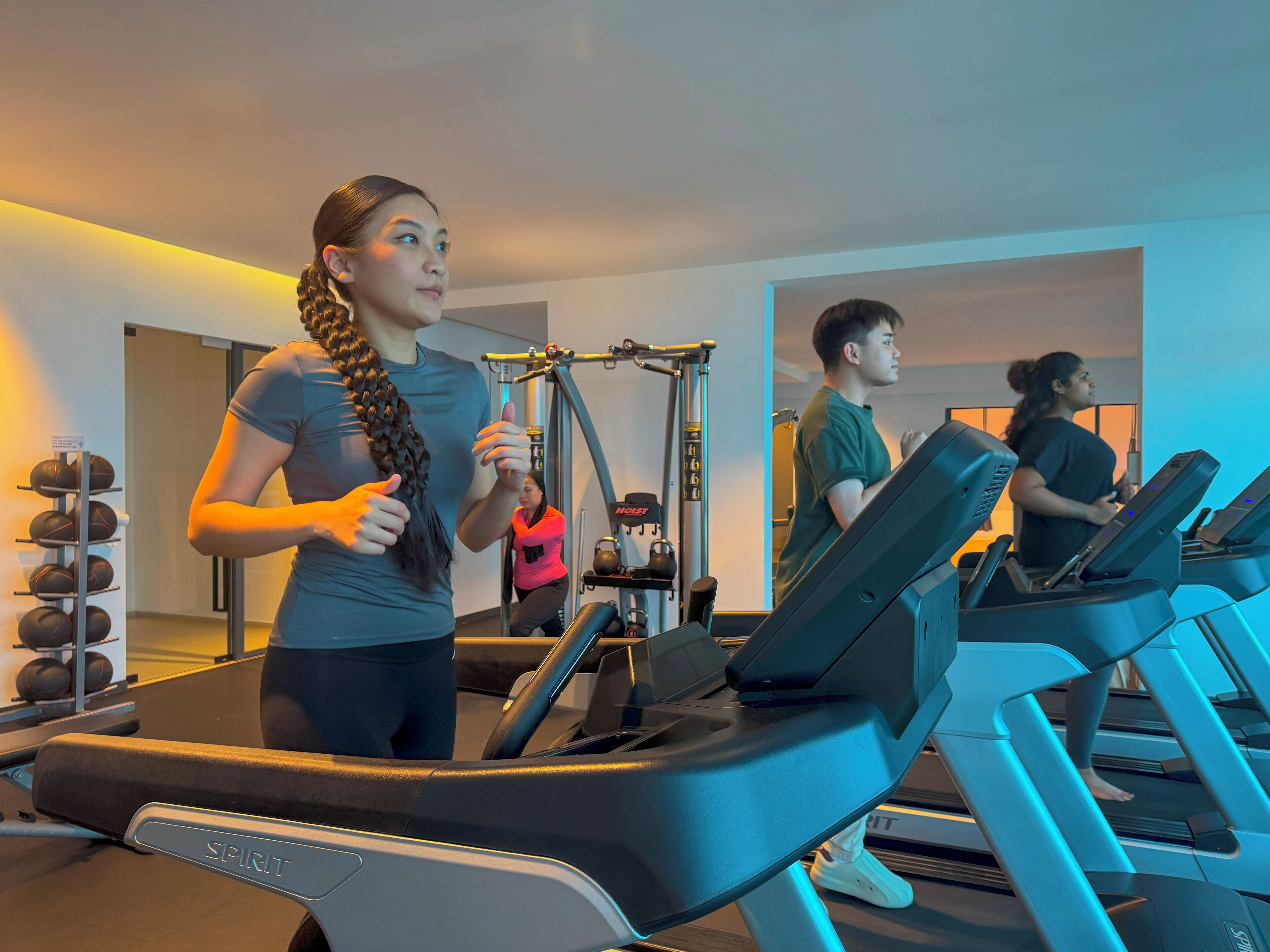A gym with treadmills, a weight rack, and a mirror.