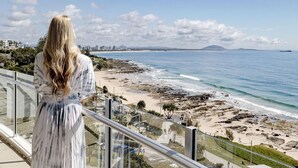 A balcony with a view of a beach and ocean.