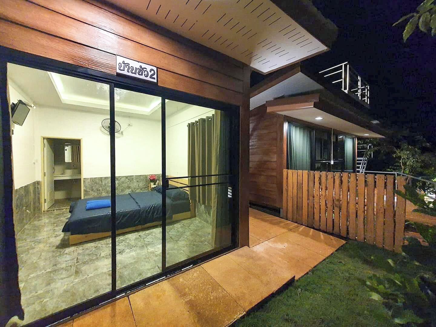 Een moderne hotelkamer met een grote schuifglazen deur, een bed en een kleine badkamer.