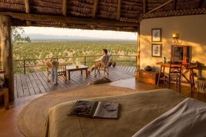 Una habitación con cama, una mesa y vistas a un paisaje desértico.