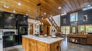 Una cocina amplia con una isla grande, armarios de madera y una estufa moderna.
