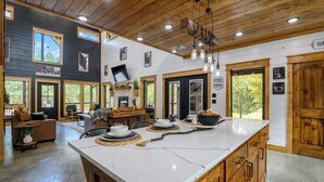 Una cocina amplia con una isla grande, armarios de madera y vistas al exterior.