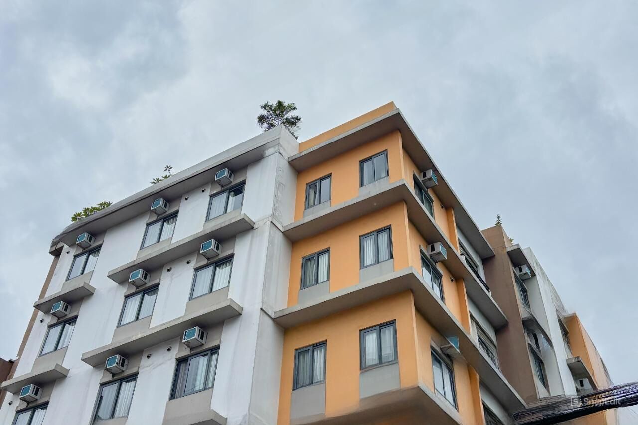 A multi-story building with balconies and air conditioning units.