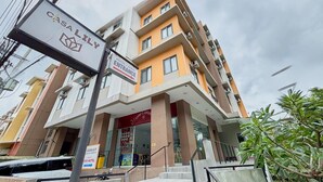 A multi-story hotel with a prominent entrance sign, a visible restaurant, and a staircase leading to the entrance. - Casa Lily Hotel Quezon City (Quezon City)