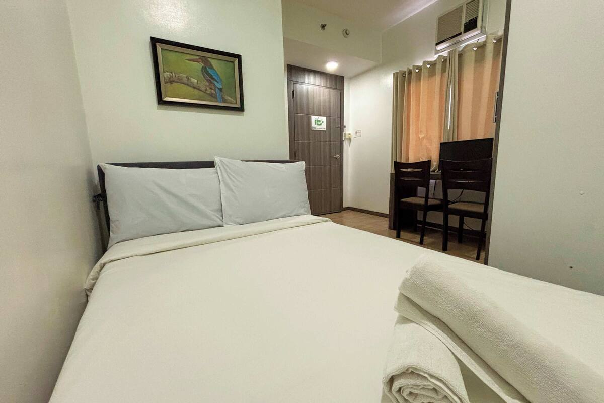 Habitació d'hotel amb un llit, una taula i una cadira.