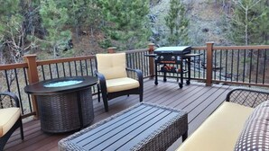 Eine Terrasse mit Korbmöbeln, einem Grill und einem Whirlpool.