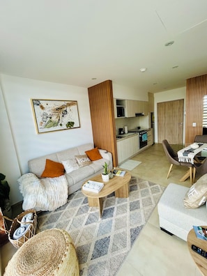 A modern living room with a sofa, coffee table, and a dining area with chairs. - New modern apartment very well located! (Pocitos)