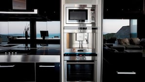 Una cocina moderna con electrodomésticos integrados, un ventanal y vistas al exterior.
