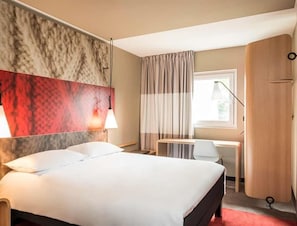 A hotel room with a bed, desk, chair, and wardrobe. - Ibis Jouy en Josas Velizy (Jouy-en-Josas)