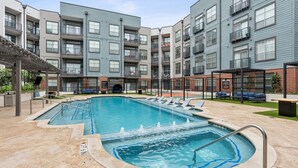 A multi-story residential building with a swimming pool, outdoor seating, and a covered patio area. - Deep Ellum Comfort Stay, Sleeps 5 - Walk to Nightlife & Dining (Dallas)