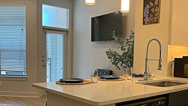 A modern kitchen with a central island, built-in dishwasher, and pendant lighting. - Deep Ellum Comfort Stay, Sleeps 5 - Walk to Nightlife & Dining (Dallas)