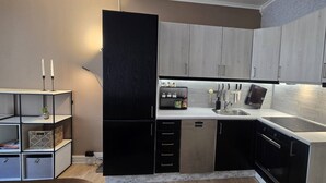 Uma cozinha compacta com eletrodomésticos modernos, forno embutido e micro-ondas.