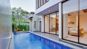A modern house with a swimming pool, large glass doors, and a well-maintained garden. - Villa Laviosa - Petitenget (Seminyak)