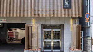 A hotel entrance with a modern design, featuring a metal gate and a sign indicating a 23m height limit. - b&Namba3 (Osaka)