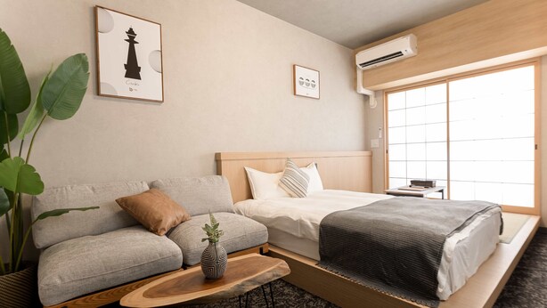 A modern hotel room with a sofa, bed, and a large window. - b&Namba3 (Osaka)