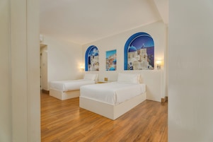 Une chambre d’hôtel avec deux lits, un plancher en bois et des œuvres d’art murales représentant un paysage côtier.