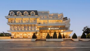 Un hotel de varios pisos con una entrada imponente, varios balcones y una fachada bien iluminada.
