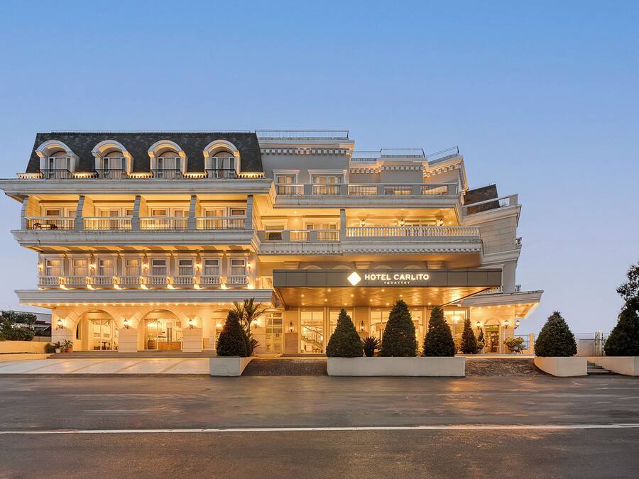 Un hotel de varios pisos con un diseño arquitectónico clásico, con balcones y una entrada destacada.