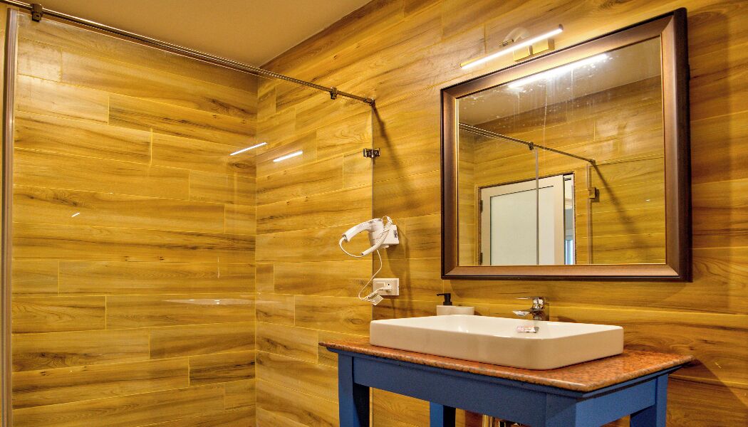 A bathroom with wooden walls, a white sink, and a mirror.