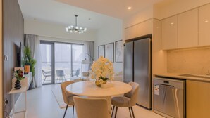 Una cocina moderna con lavavajillas integrado, un refrigerador grande y un comedor con una mesa redonda y sillas.