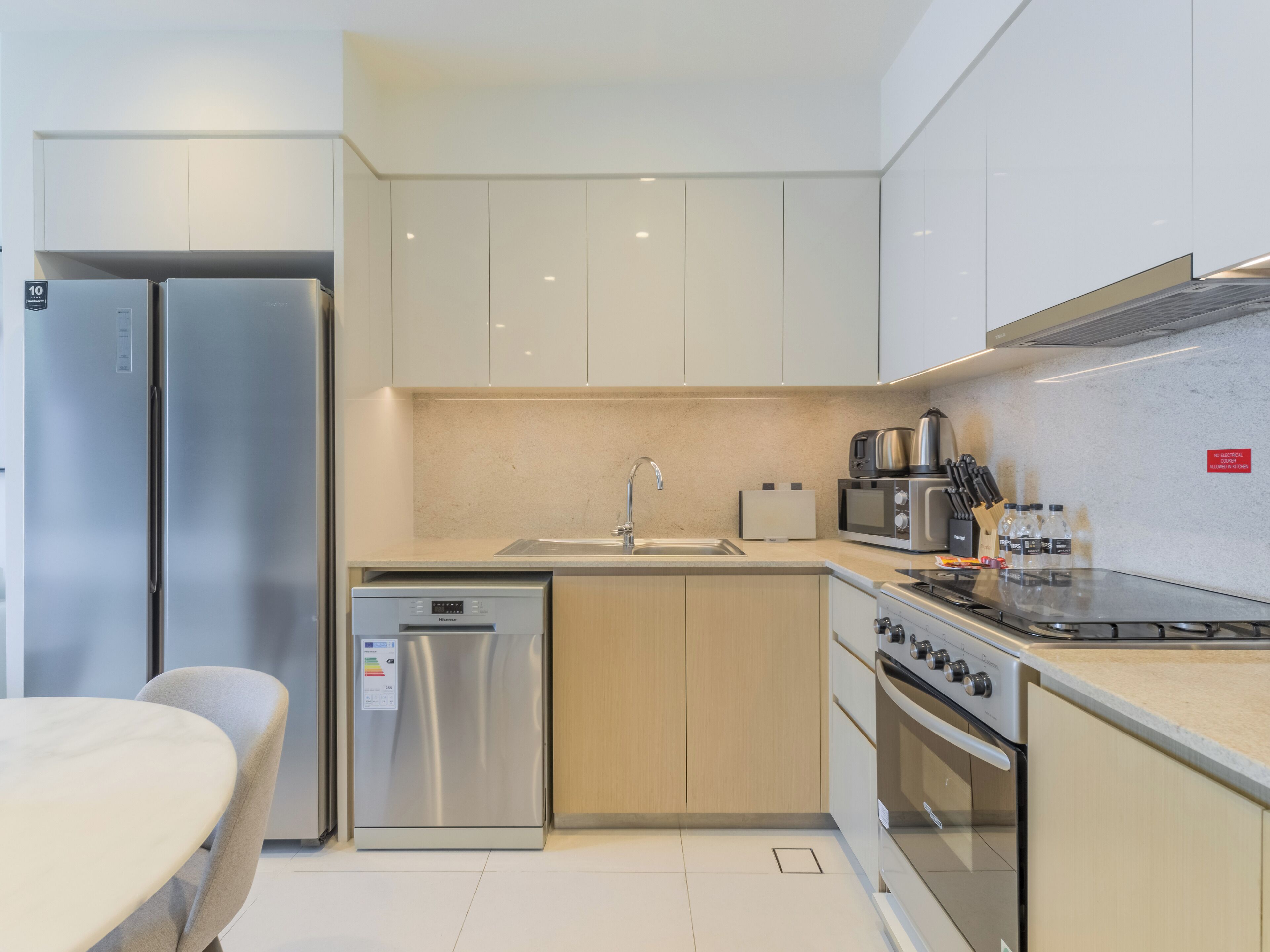 Una cocina moderna con electrodomésticos de acero inoxidable, lavavajillas y cocina a gas.