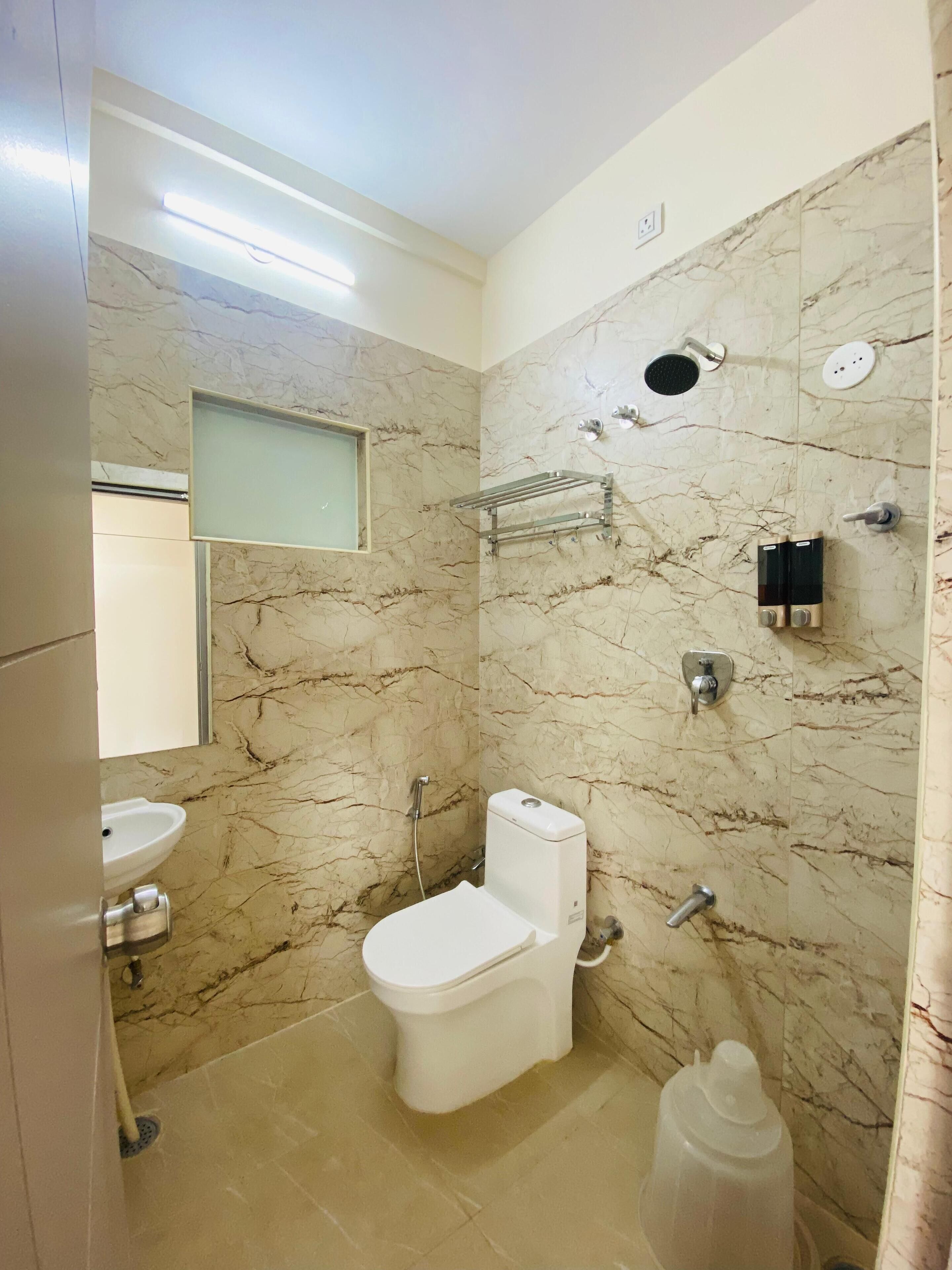 A bathroom with a toilet, sink, and shower.