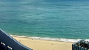 Une vue sur la plage, avec un ciel dégagé et une mer calme.