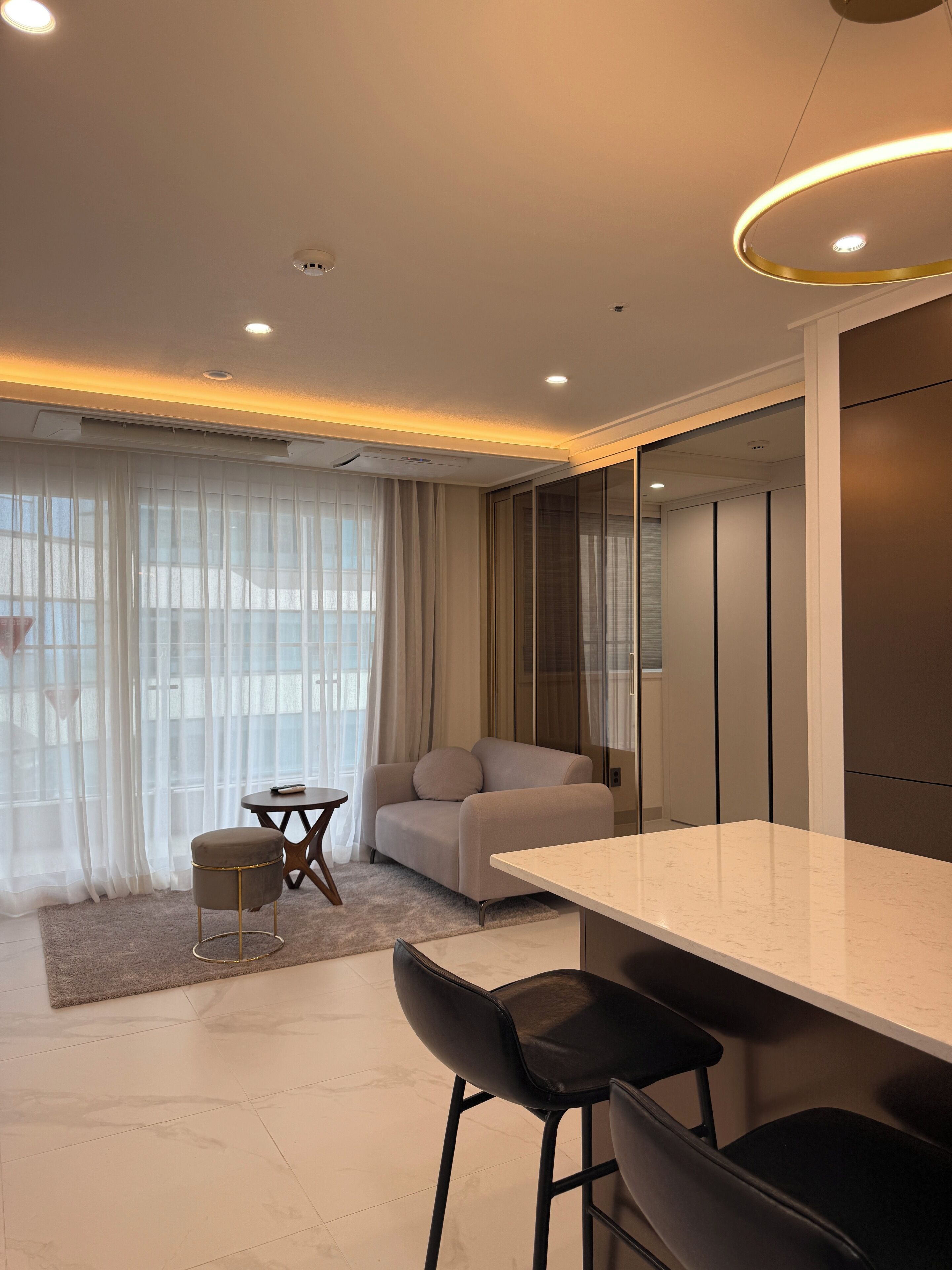 Un salon moderne comprenant un canapé, une table basse et un coin repas avec un bar.