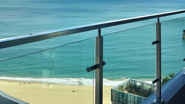 Un balcon avec vue sur l’océan et la plage.