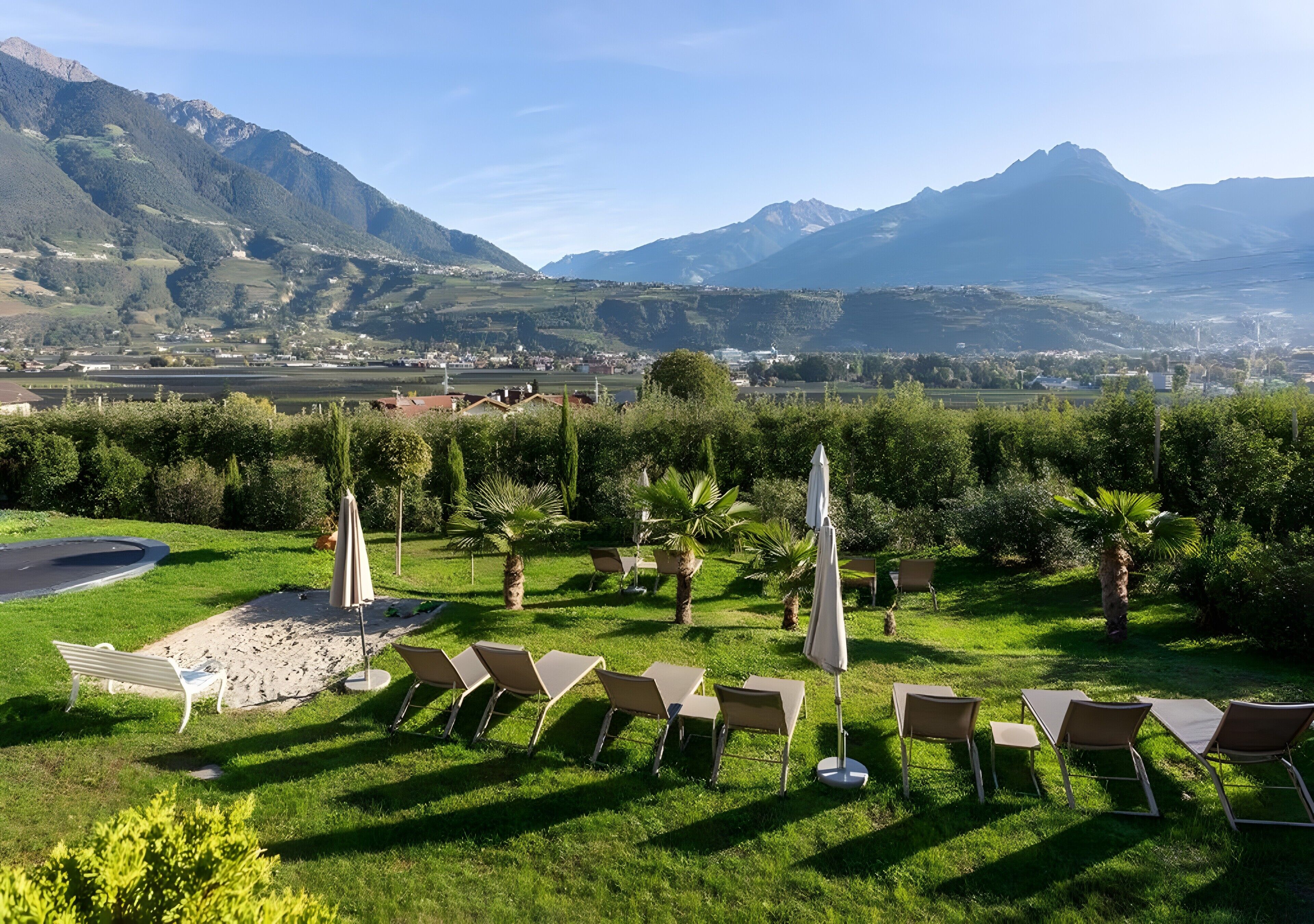Un giardino con posti a sedere all'aperto e vista sulle montagne.