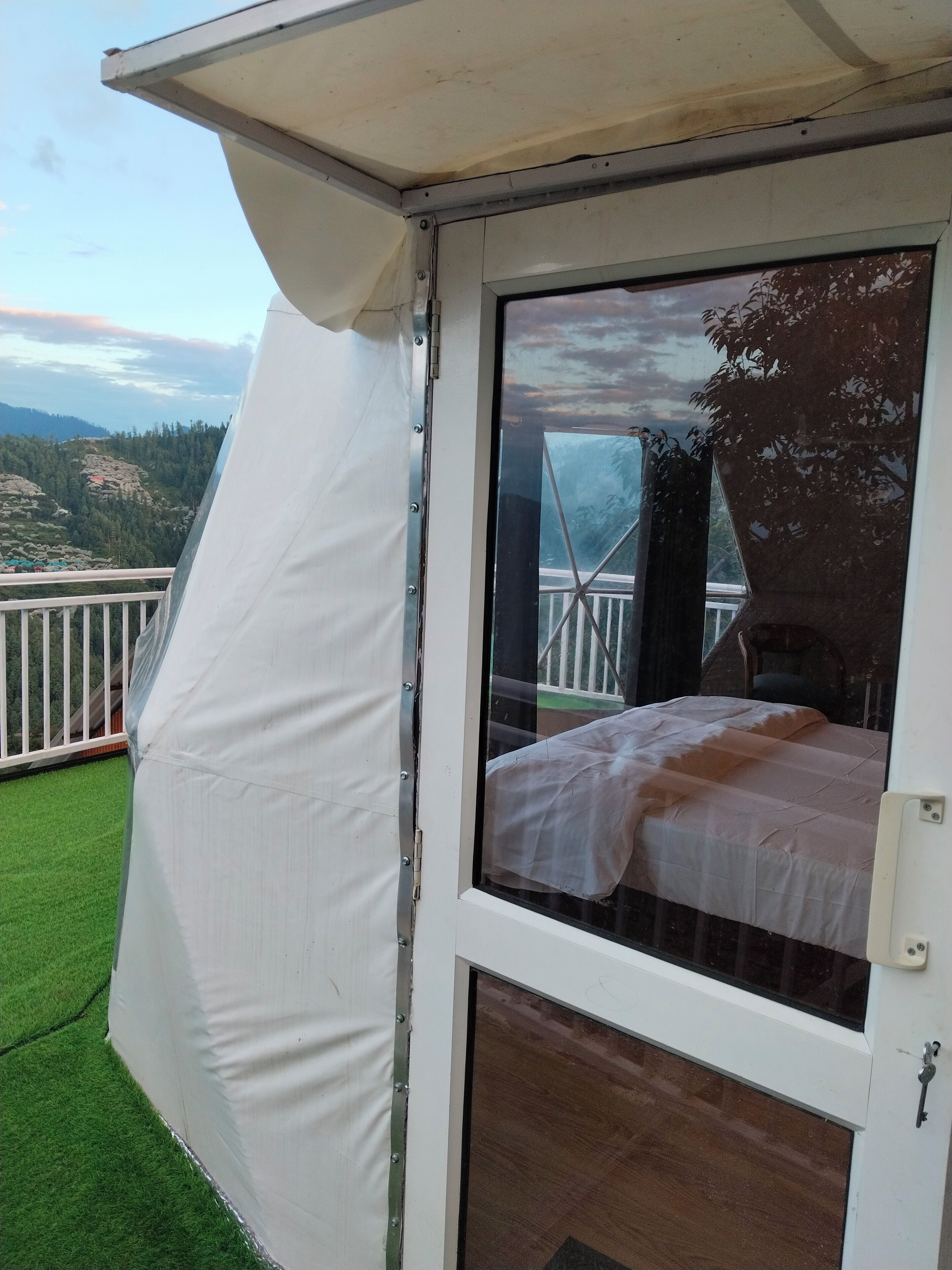 Una habitación con cama, ventana y vistas a un balcón.