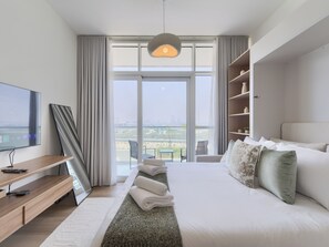 Estudio Deluxe, balcón, vista a la ciudad | Área de sala de estar | Smart TV de 55 pulgadas con canales digitales 