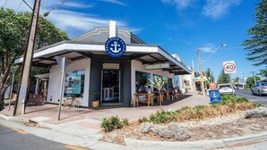 A building with a nautical theme, including an anchor logo and a sign reading "Seafood Pub." - Salt at Arlo`s - Cosy Comfort near Glenelg Beach (Glenelg South)