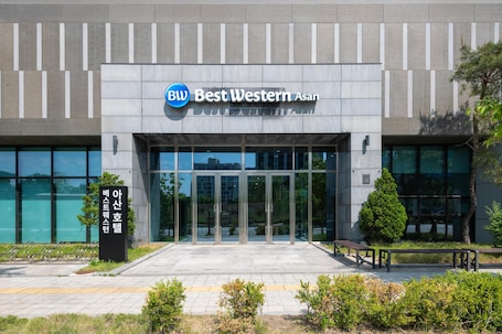 A modern building with a glass entrance, a sign reading 'Best Western Asan,' and a wheelchair-accessible ramp.. Best Western Asan Hotel
