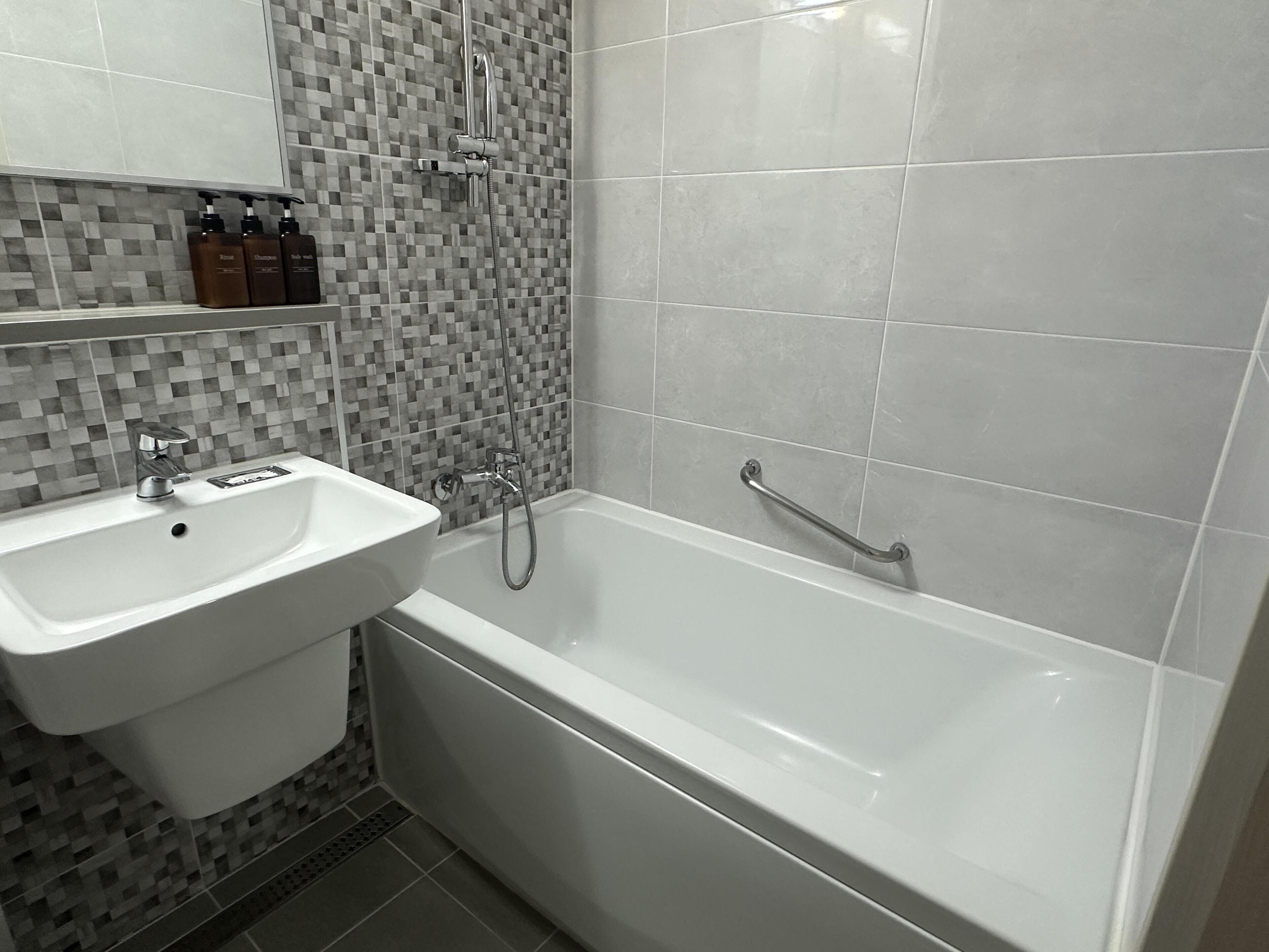 Combined shower/bathtub, hair dryer, slippers, towels