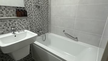 Combined shower/bathtub, hair dryer, slippers, towels