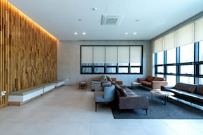 A modern lobby with seating, large windows, and a wooden accent wall.