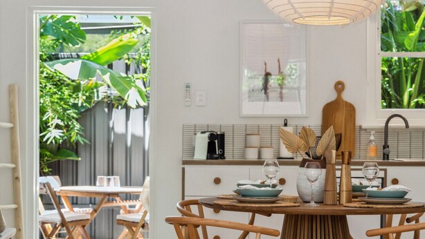 Un espace repas avec une table ronde, des chaises en bois et un luminaire suspendu.