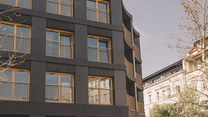 Un immeuble à plusieurs étages doté de grandes fenêtres et de balcons.